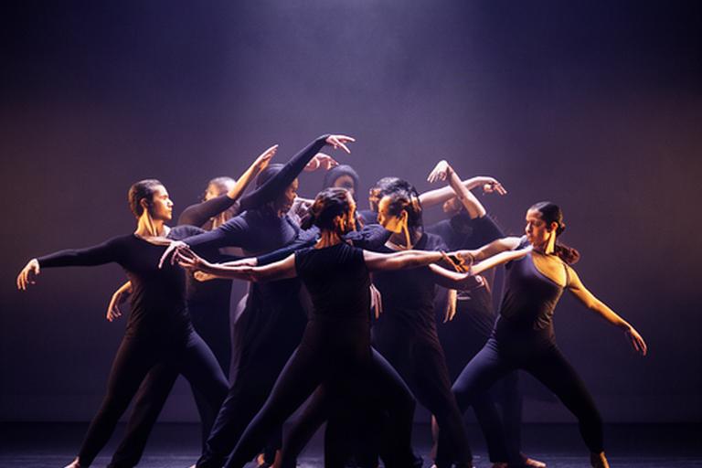 Grupo de intérpretes formando una composición durante una actuación de danza contemporánea
